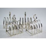 A set of four silver four-division toast-racks with shield-shaped handles,