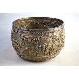 A Burmese white metal bowl, decorated in high relief with high ranking figures in narrative scenes,
