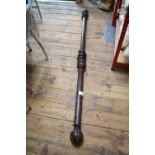 A dark wood curtain pole with studded ball finials, complete with rings,