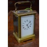 A large brass carriage clock with enamel dial,
