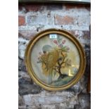 A pair of early 19th century silk needlework on silk pictures of parrots, in circular gilt frames,