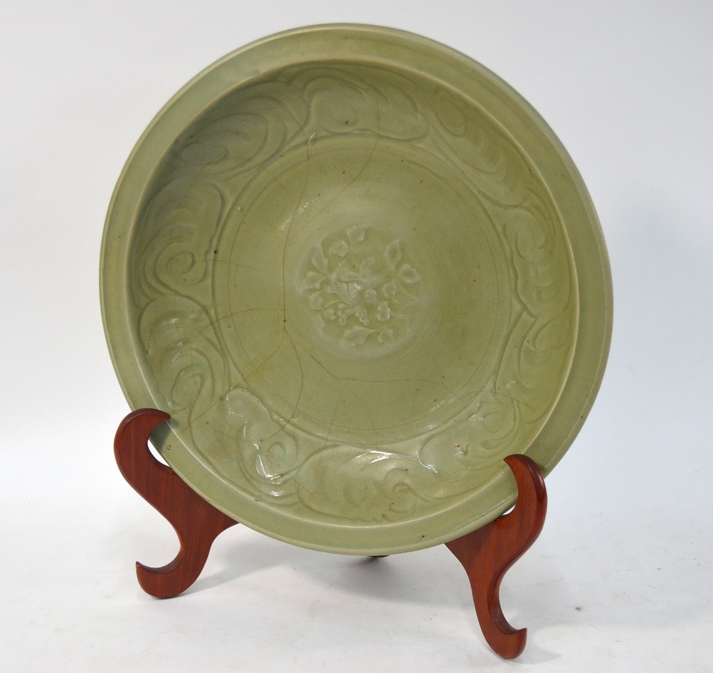 A Ming celadon dish of circular form, decorated at the centre with a floral spray,