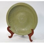 A Ming celadon dish of circular form, decorated at the centre with a floral spray,