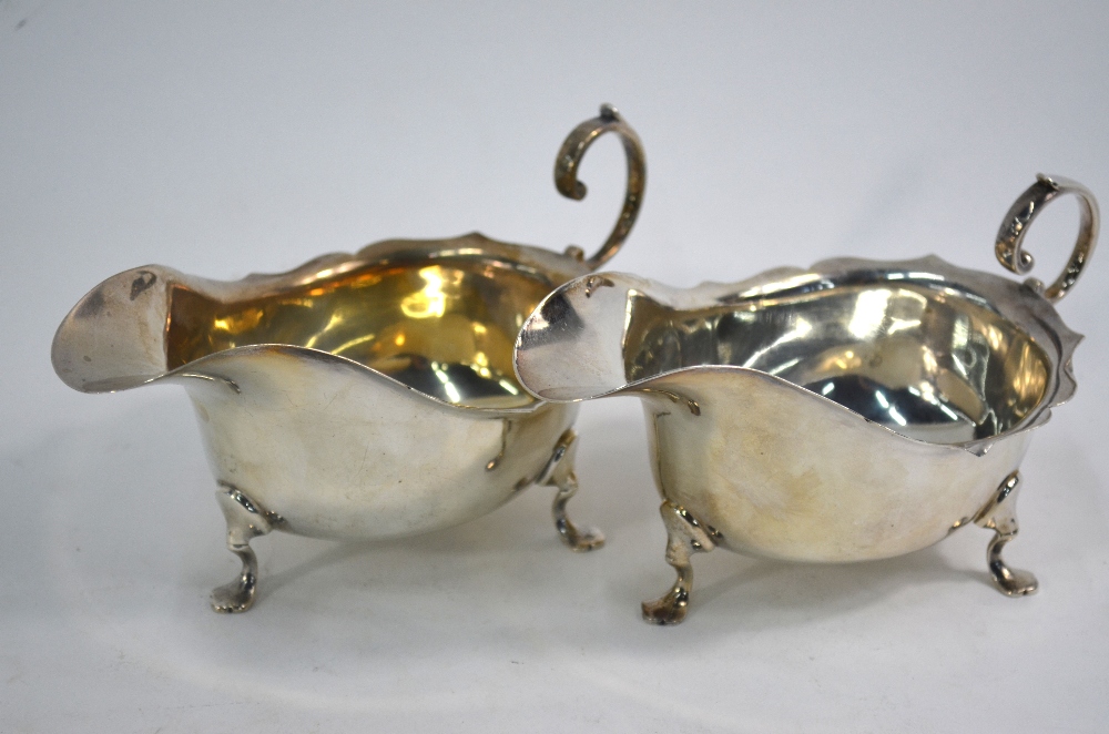 A near-matched pair of silver sauce boats with cut rims, scroll handles and pad feet, - Image 2 of 4