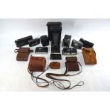 A collection of vintage cameras including Kodak Junior and other folding cameras,
