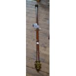 A mahogany curtain pole with decorative gilded metal finials, complete with wall mounts,