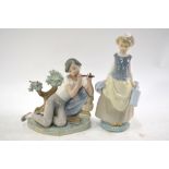 Two Lladro figures - Boy playing a pipe, 20 cm high and a Girl carrying flagons,