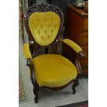 A pair of Victorian style stained wood open armchairs with buttoned backs,