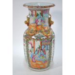 A Canton famille rose vase with trumpet neck and typically decorated panels on a lime-green ground,
