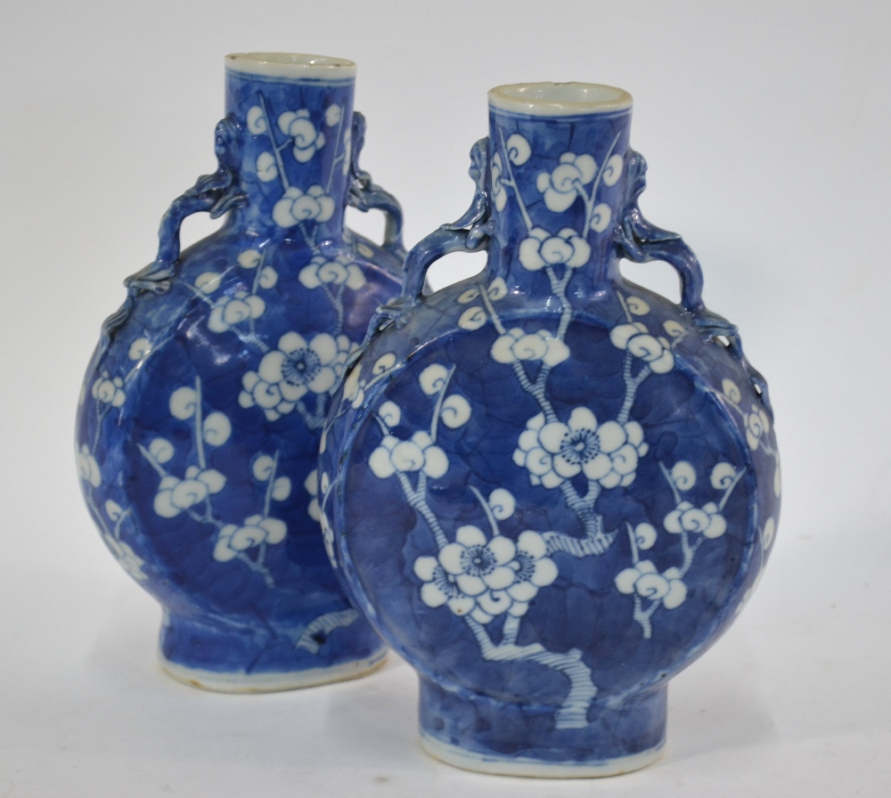 A pair of blue and white pilgrim flasks, each one decorated with a design of prunus in flower; 21.