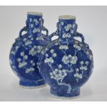 A pair of blue and white pilgrim flasks, each one decorated with a design of prunus in flower; 21.