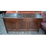 A 17th/18th century oak coffer of joint and panelled construction beneath a wide two-plank top,