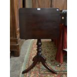 A rectangular mahogany tilt-top occasional table on turned column and triform supports