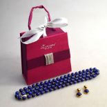A single row of uniform size lapis lazuli beads, with small gold spacers between,