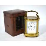 A French oval brass carriage clock with enamel dial,