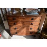 A George III mahogany bowfront chest of four long drawers with turned pulls and compartmented upper