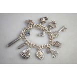 A silver double curb bracelet with padlock and eleven various charms attached
