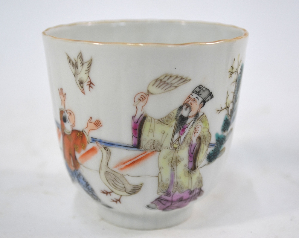 A famille rose cup, decorated with a pair of scholars on a garden terrace with two boys,