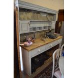 A large painted pine kitchen dresser with scrubbed top, plate with shelves and cupboards,