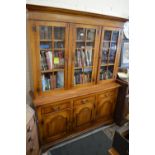 A Brights of Nettlebed oak cabinet bookcase with three glazed upper doors above frieze drawers and
