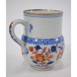 A Chinese Imari tankard, decorated with horizontal lines above floral designs in typical colours, 9.