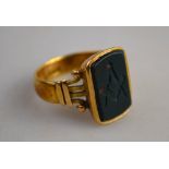 A Masonic ring set with engraved bloodstone, yellow metal set stamped 18ct,