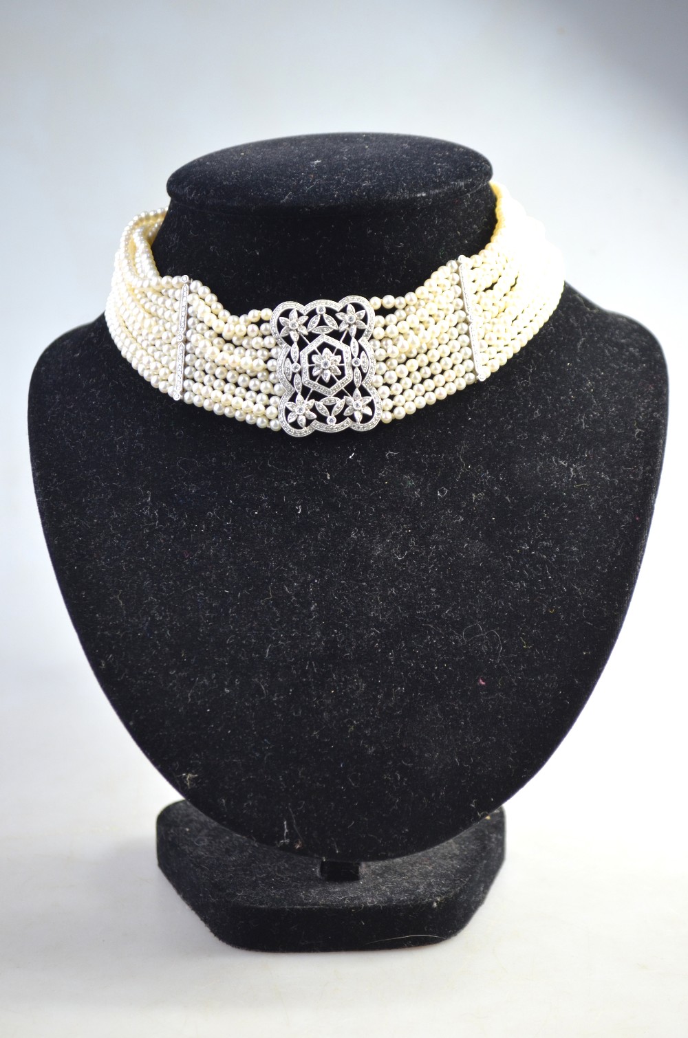 An Edwardian style ten-row cultured pearl necklace with rectangular pierced centrepiece set overall