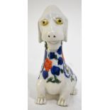 A Japanese Imari figure of a seated dog, decorated in underglaze blue, copper red and green, 12.