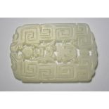 A green jade pendant of whitish hue, designed with a key-fret pattern and reticulated motifs,
