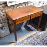 An Edwardian cross banded two drawer side table raised on square tapering legs to brass castors,