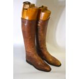 A pair of vintage tan leather gentleman's boots with three-section boot trees with brass pulls