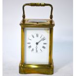 A brass carriage clock, the movement repeat-striking on a coiled gong, enamel dial,