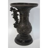 A tall bronze vase with trumpet neck and separately cast handles, decorated in relief with a dragon,