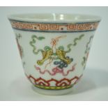 A small famille rose wine cup, decorated with sacred symbols; 5cm high,