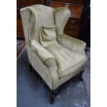 A George III style wing armchair, re-upholstered in gold dralon,
