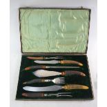 An Edwardian cased electroplated seven-piece carving set, the antler handles with silver ferrules,