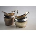 Two George III silver helmet cream jugs with engraved decoration and reeded handles,