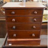 A Victorian mahogany miniature chest of four long drawers with turned pulls,