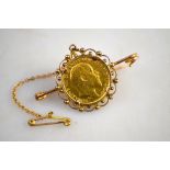 A 1907 half sovereign in yellow metal scrollwork brooch mount, approx 7.