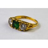 An emerald and diamond three stone ring, 18ct yellow gold carved setting,