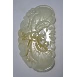 A small green jade applique or other ornament of mottled white hue,