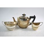 A matched silver three-piece half-reeded bachelor tea service, Birmingham 1895/1935, 12.