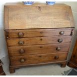 A Georgian provincial mahogany bureau with blind-fret carved fitted interior above four long