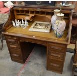 An oak tambour roll-top desk with fitted interior over six drawers