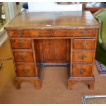 An 18th century feather banded walnut kneehole desk,
