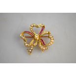A yellow gold open bow style brooch set with baguette rubies and half pearls stamped 15ct