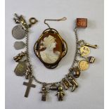 A charm bracelet with various charms, mostly silver, including 10 shilling note,