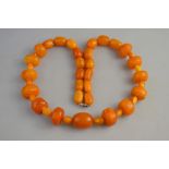A reconstituted amber necklace formed of large and small beads of varying sizes,