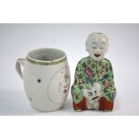 A famille rose figure of a seated Manchu/Chinese boy, 16 cm high; together with a famille rose,