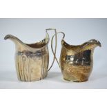 Two George III silver helmet cream jugs with engraved decoration and reeded handles,